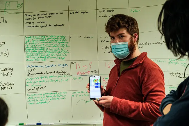 STUDENT fills out the board with relevant solar wind data. Photo: Maria Philippa Rossi/UNIS