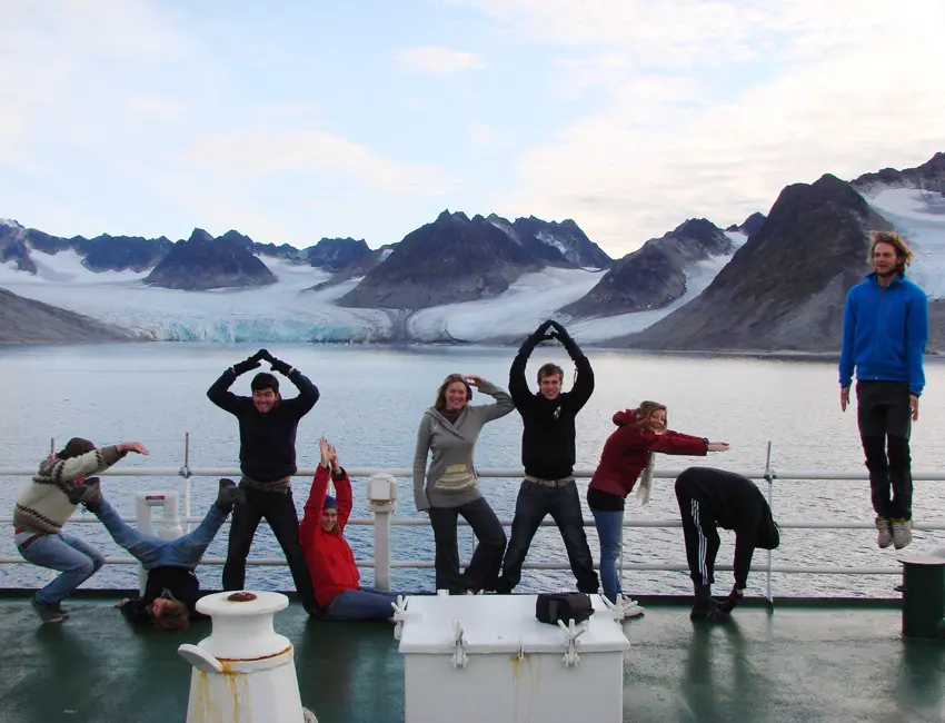 Students on ship deck in front of glacier