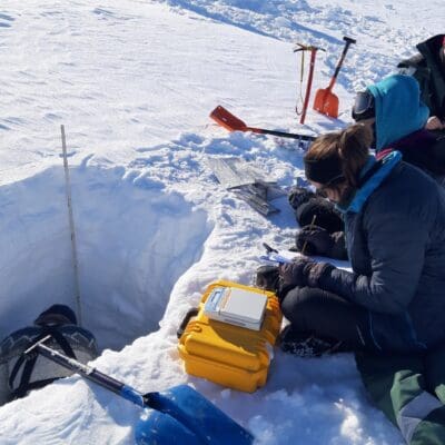 Students of the Arctic winter ecology course are conducting snow pit measurements of snow temperature and density on Foxfonna glacier
